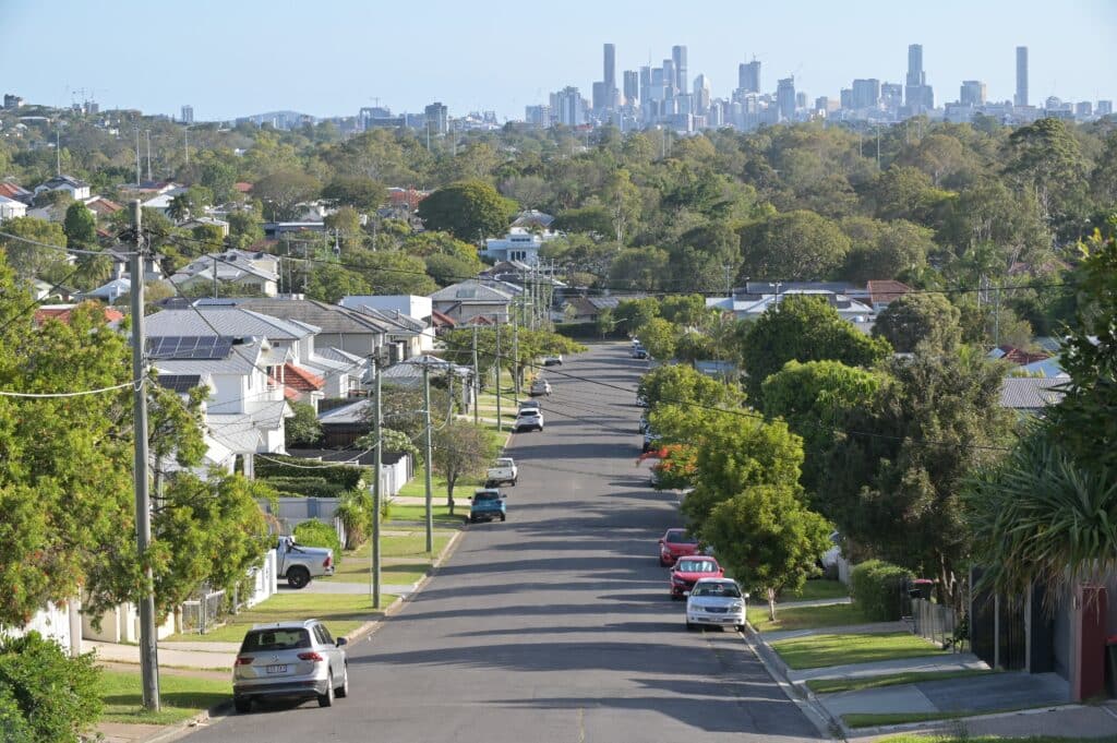 Looking down suburban street with Brisbane City skyline in background